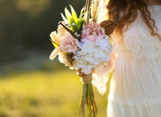 A bride and the flowers in her hand outdoorS