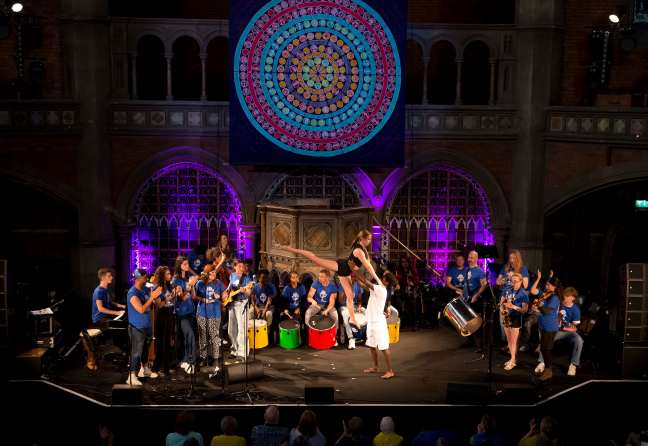 Youth singing together with a dancer in the middle